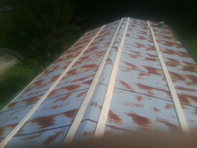 Rusted metal roof panels with new wood purlins before replacement — Storm Damage Roof Repair in Butner by Roofing Brothers